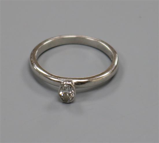 An 18ct white gold and collet set oval solitaire diamond ring, size L.